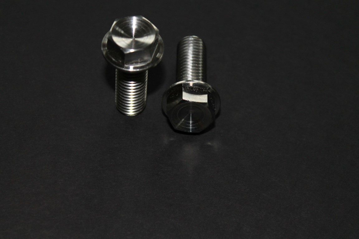 Two Metallic Screws Placed on a Dark Background