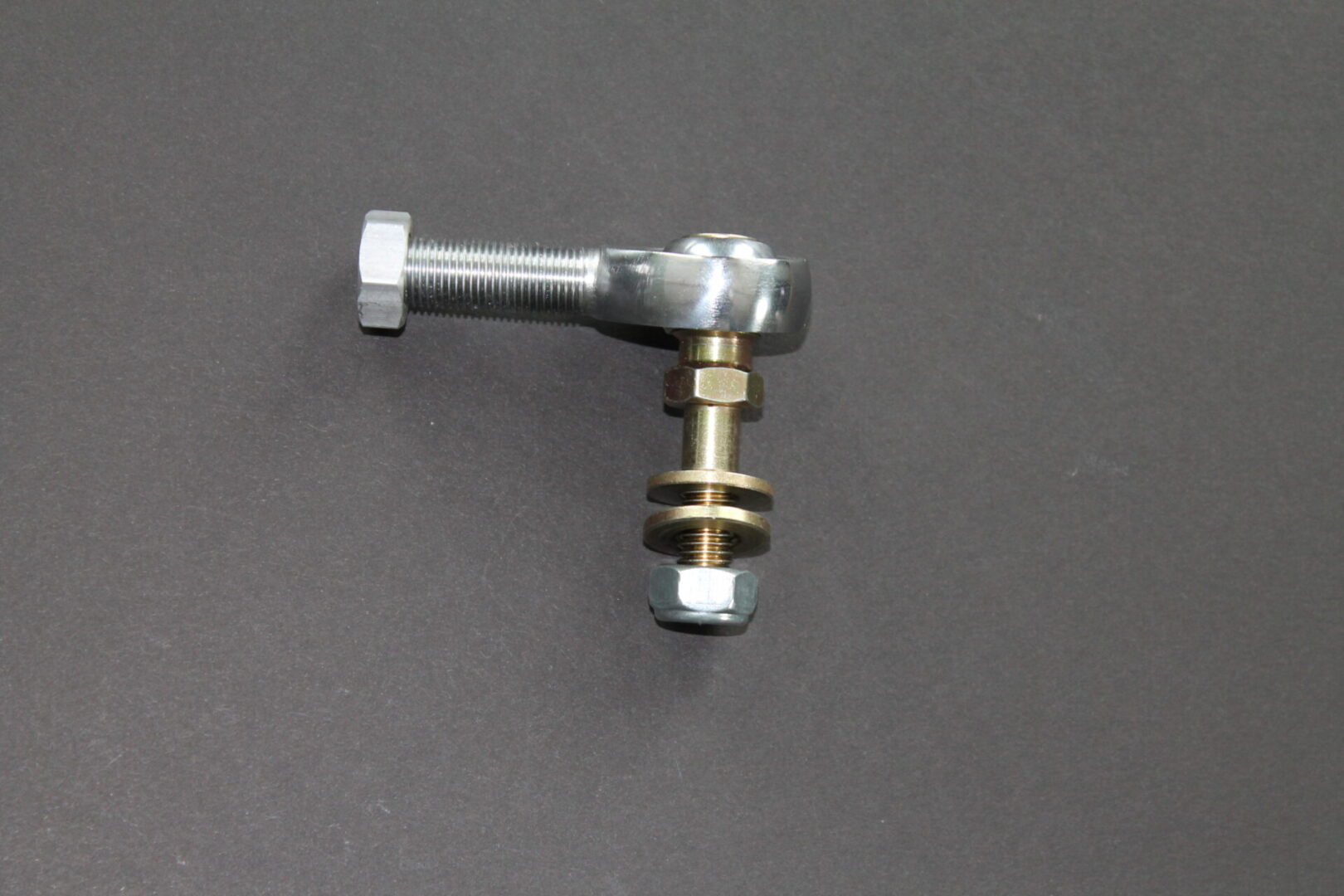 A small piece of 1/2"-20 Upper Cromoly Rod End w/ Stud Polaris on a gray surface.