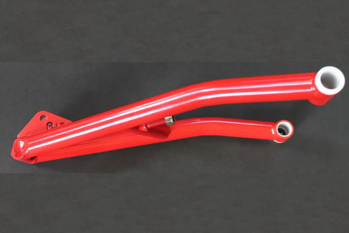 A red handlebar with a white pipe on a black background has been replaced by the 08-12 Titanium Rear Suspension Shock linkage.