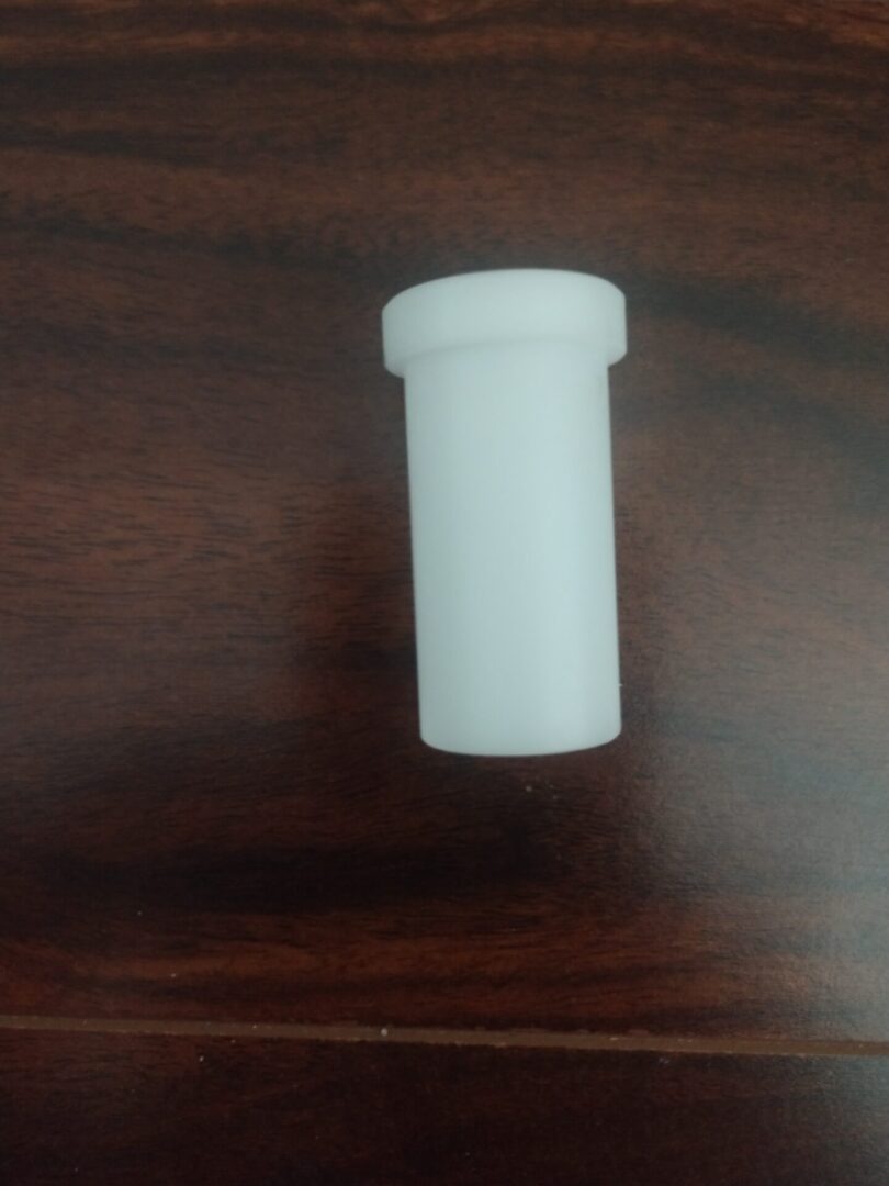 A white plastic container on a wooden table.