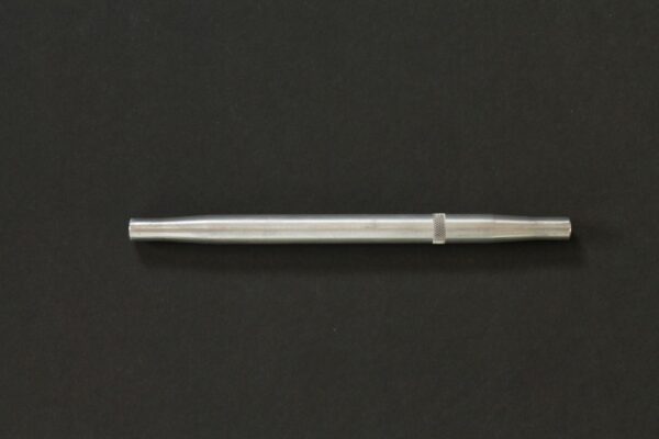 A silver pen on a black surface.