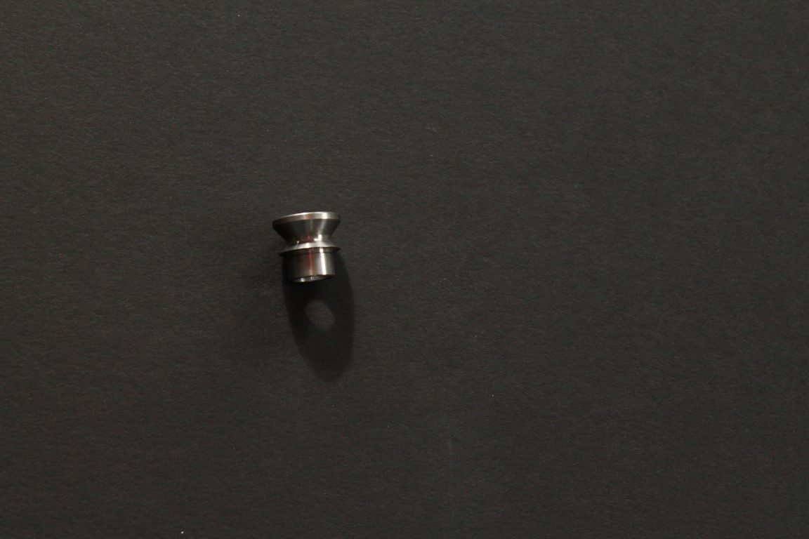A small piece of metal on a black surface.